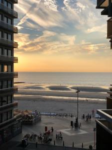 a view of the beach at sunset from a building at Le Sable Doux 4D in Middelkerke