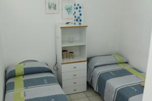 a bedroom with two twin beds and a cabinet at Rocca dei tramonti in Punta Braccetto