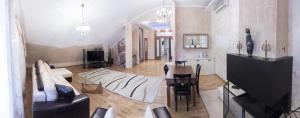 - un salon avec un canapé, une table et une télévision dans l'établissement Zhemchuzhina Hotel, à Saratov