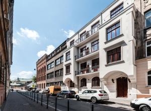 a white building with cars parked in front of it at Apartamenty L5 in Kraków
