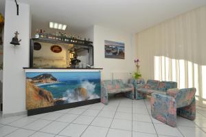 a living room with two chairs and a large aquarium at Hotel Deutsche Familien in Finale Ligure