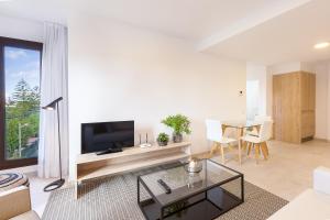 a living room with a television and a table at Plaza de La Feria Premium Apartments in Las Palmas de Gran Canaria