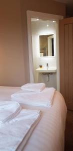シルバーデールにあるThe Silverdale Hotelのベッドルーム1室(鏡とシンク付きのベッド2台付)
