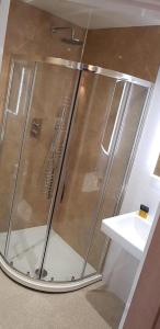 a shower with a glass door next to a sink at The Silverdale Hotel in Silverdale