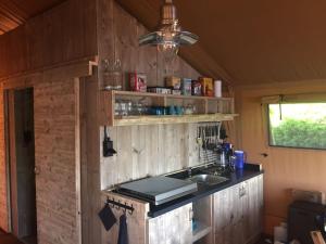 a kitchen with a sink and a counter top at Glamping Amsterdam "only to be reached by boat" in Baambrugse Zuwe