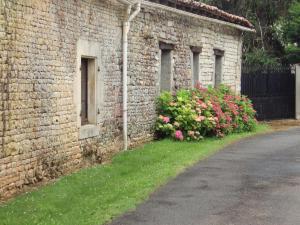 ein Backsteingebäude mit Blumen auf der Seite in der Unterkunft Les Rossignal in Villiers-le-Roux