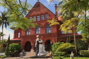 una statua di una coppia di fronte a un edificio di Four Flowers Guesthouse a Key West