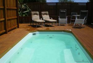 a hot tub on a deck with chairs and chairs at Cumberland Resort & Spa in Burnt Pine