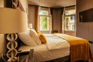 um quarto com uma cama com um candeeiro e 2 janelas em Premium Apartments Villa Herkules em Opatija