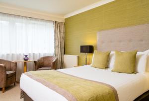 a hotel room with a large bed and a window at Lea Marston Hotel in Lea Marston