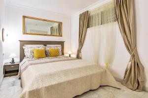 Un dormitorio con una cama con almohadas amarillas y un espejo. en Wonderful apartment in Los Gigantes Buena Vista, en Acantilado de los Gigantes 11 fotos más