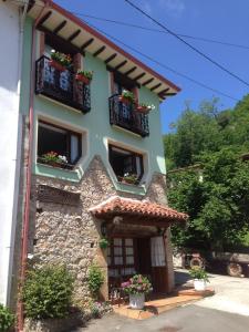 ein Gebäude mit Balkonen und Blumenkästen darauf in der Unterkunft Alojamientos Casa Luisa in Puertas