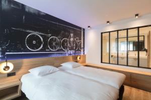 ein Schlafzimmer mit einem weißen Bett und einer schwarzen Wand in der Unterkunft Hotel Leo Station, Villa et Annexes in Bastogne