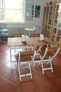een houten tafel en stoelen met een tafel en banken bij La Casa nel Bosco in Savio di Ravenna