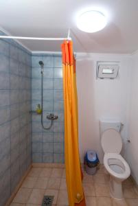 y baño con ducha y cortina de ducha de color naranja. en La Livada, en Greci