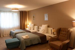 una habitación de hotel con 2 camas y una silla en Dworek, en Szonowice