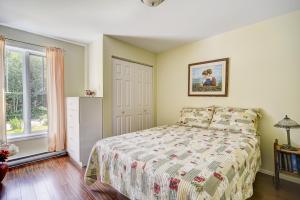 un dormitorio con una cama y una ventana en Entre roc et montagne, en L'Anse-Saint-Jean