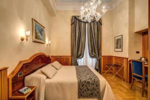 a bedroom with a bed and a chandelier at Relais Conte Di Cavour De Luxe in Rome