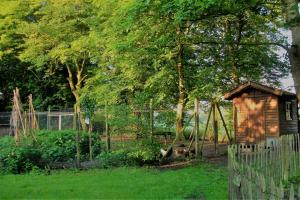 een houten schuur in een tuin naast een hek bij Landhaus-Nordseekueste in Jethausen