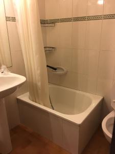 ein Badezimmer mit einer Badewanne, einem Waschbecken und einem WC in der Unterkunft Alojamientos Casa Luisa in Puertas