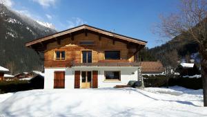 a wooden house with snow in front of it at Appartement avec Terrasse in Chamonix-Mont-Blanc