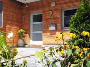 Uma casa com um ramo de flores amarelas à frente. em Leos Alpenblume inklusive Sommer Bergbahnticket em Oberstdorf