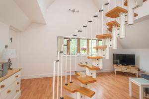 a living room with stairs and a tv at 83 Downs Hill in Beckenham
