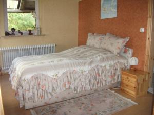 a bedroom with a bed and a dresser and a window at Landhaus-Nordseekueste in Jethausen