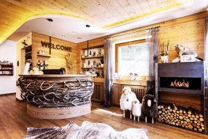 a living room with a fireplace in a log cabin at Hotel Jägerheim 3S in Selva di Val Gardena +110 photos