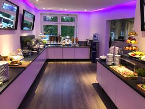 a kitchen with purple lighting in a restaurant at Wincent Hotel in Sinsheim