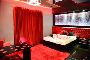 Helus Motel في باسو فوندو: غرفة نوم حمراء بسرير وستارة حمراء