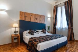 ein Schlafzimmer mit einem großen Bett und einem Fenster in der Unterkunft The Code Hotel in Rom