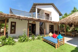 a villa with a chair and a house at An Bang Seastar Boutique Villa in Hoi An