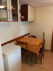 a small kitchen with a table and a refrigerator at Apartment Nono Anton in Kraljevica