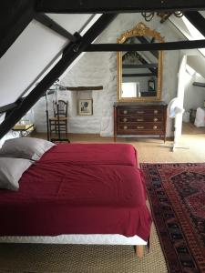 1 dormitorio con cama roja y espejo en Villa Aman An Ty, en Belz