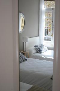 1 dormitorio con 2 camas, espejo y ventana en 7 Moons Bed & Breakfast, en Valencia