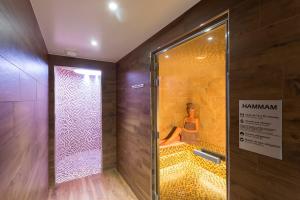 a woman sitting on a bench in a shower at Hotel Restaurant Spa du Tumulus Carnac in Carnac