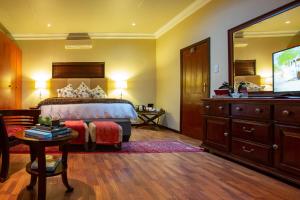 1 dormitorio con 1 cama, vestidor y TV en Spacube Luxury Suites and Spa en Pretoria