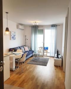 a living room with a blue couch and a table at Apartment Sole in Zadar