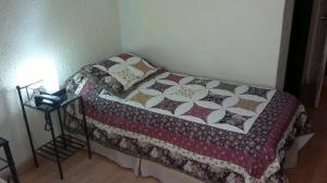 Una cama con edredón en una habitación en Hotel Marbella, en Punta del Este