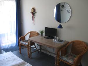 Zimmer mit einem Schreibtisch mit einem Computer und 2 Stühlen in der Unterkunft Hotel Garni Central in Triberg
