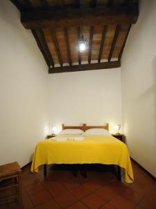 a bedroom with a bed with a yellow blanket at Residence San Bartolomeo in Città di Castello