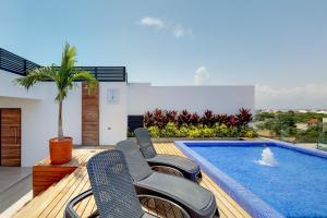 un patio avec des chaises et une piscine dans l'établissement Icono Playa Condos, B307, à Playa del Carmen