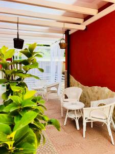 patio z białymi krzesłami i czerwoną ścianą w obiekcie B&B Red Village w mieście Chieti