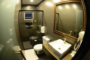 a bathroom with a sink and a shower and a toilet at Helus Motel in Passo Fundo