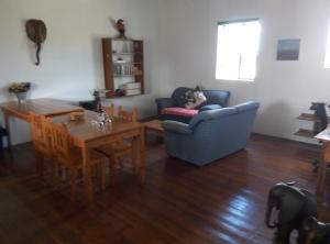 a living room with a blue couch and a table at Infinity farm in Riversdale