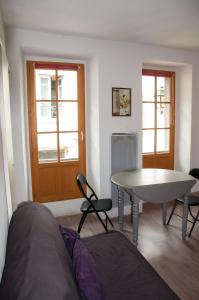 a living room with a table and a table and chairs at Appartement proche station in Luchon