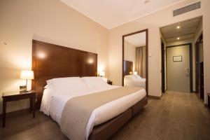 a bedroom with a large bed and a large mirror at Hotel Motel Ascot in Lissone