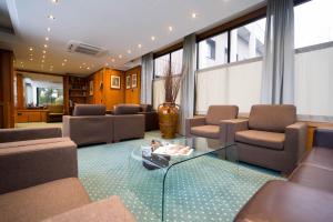 uma sala de estar com sofás e uma mesa de vidro em Hotel Motel Ascot em Lissone