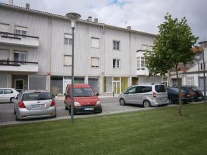 een groep auto's geparkeerd voor een gebouw bij Jardim à vista in Aveiro